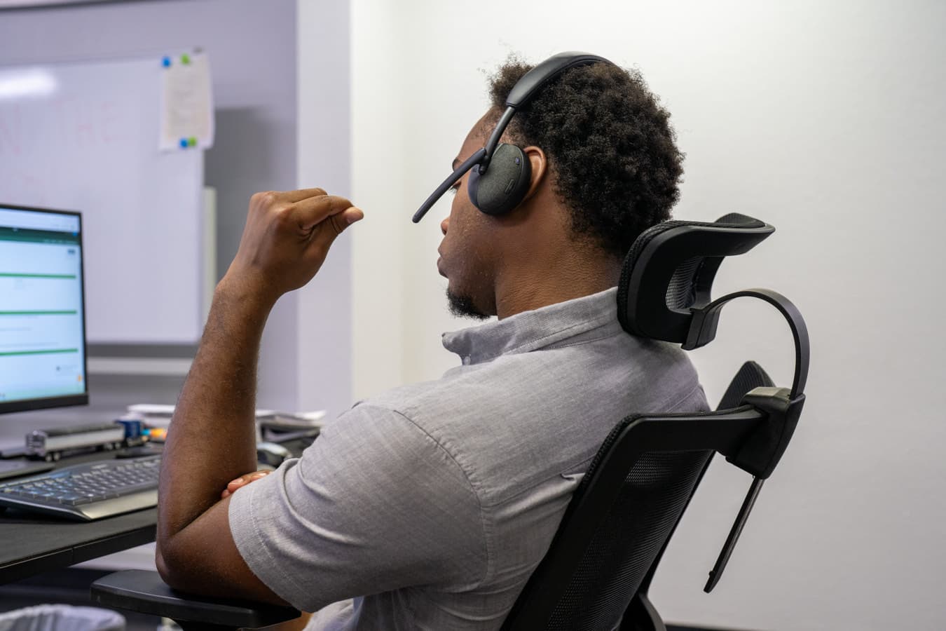 An account manager on a headset call at their desk.